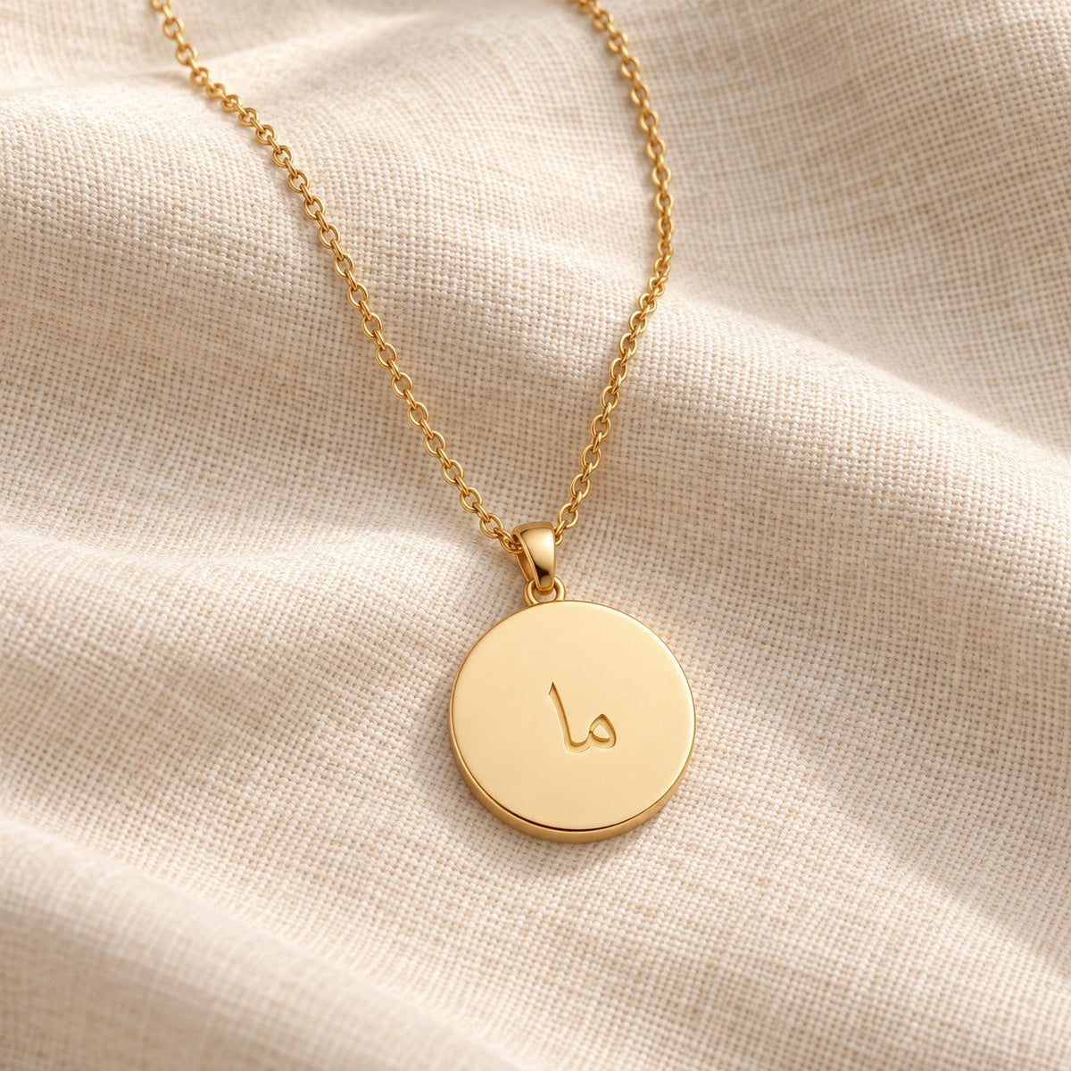 Arabic Initial Pendant Necklace 18k on cream linen