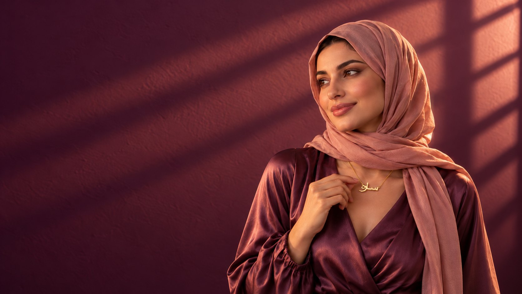 Woman wearing a Nadira Arabic name necklace in 18k gold